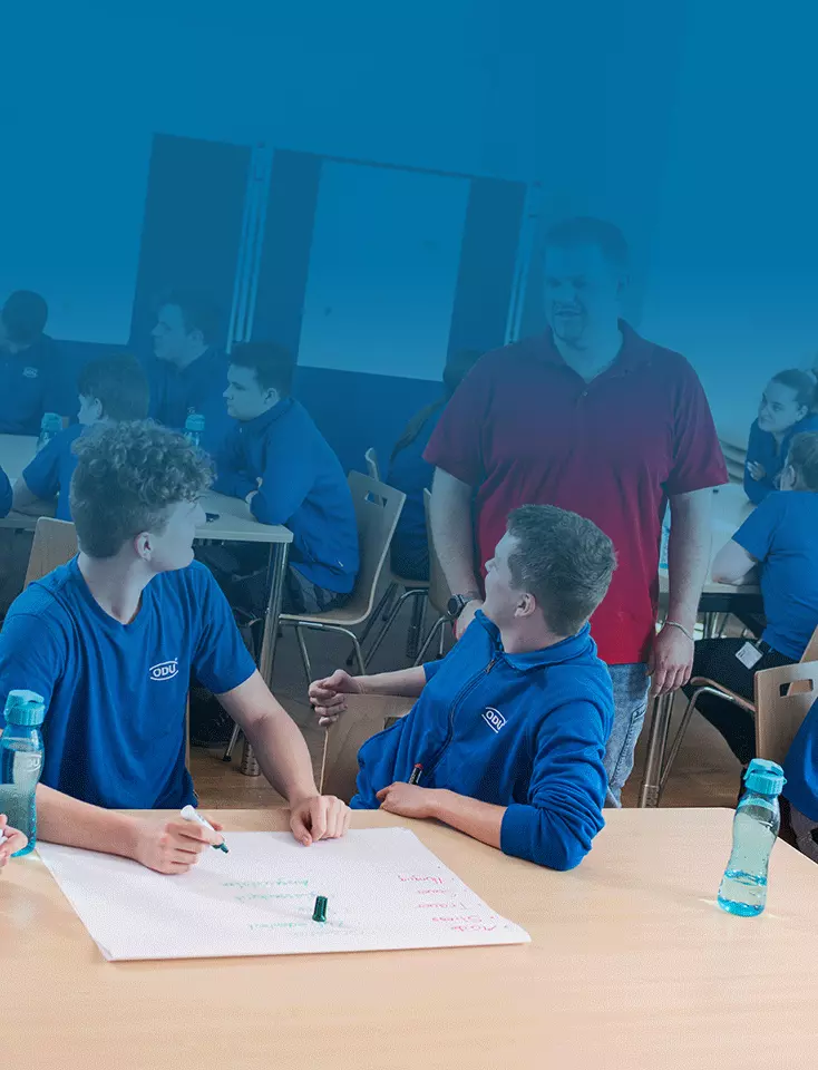 ODU trainees sit at tables and write on posters during a workshop.