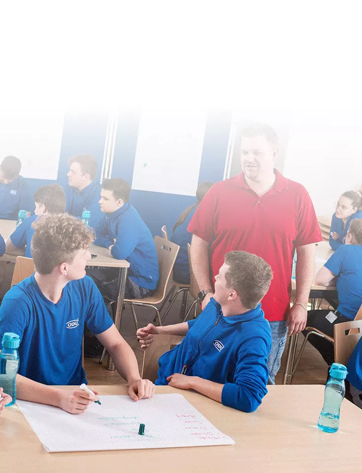 ODU trainees sit at tables and write on posters during a workshop.