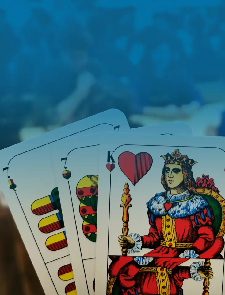 Three playing cards with a group of people in the background.